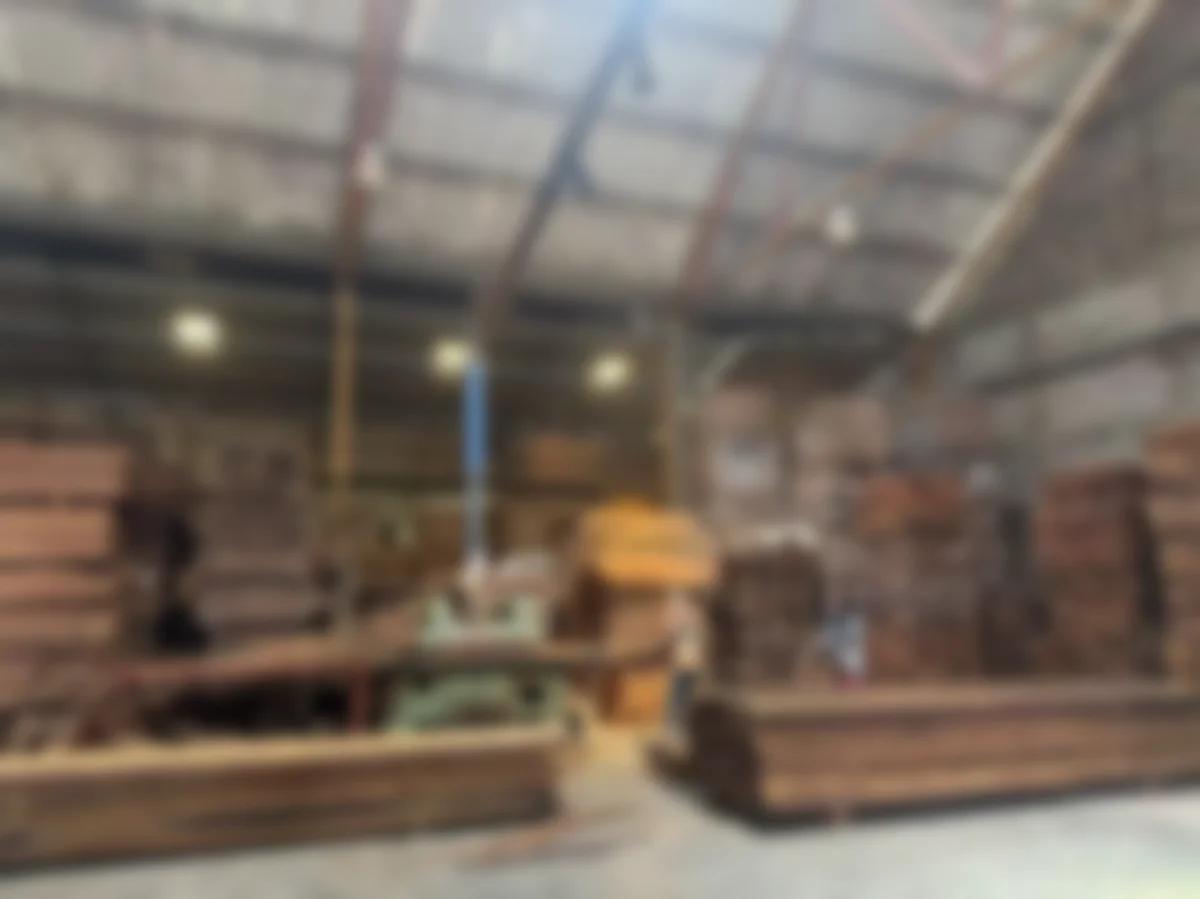 Timber processing warehouse interior with industrial woodworking machinery and finished lumber